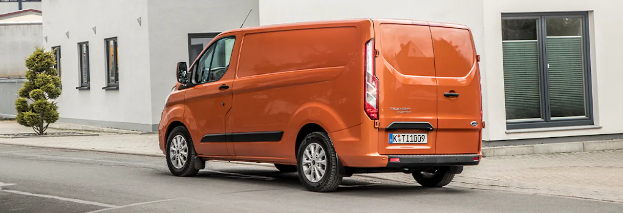 Ford Transit Custom arancione davanti a un edificio residenziale